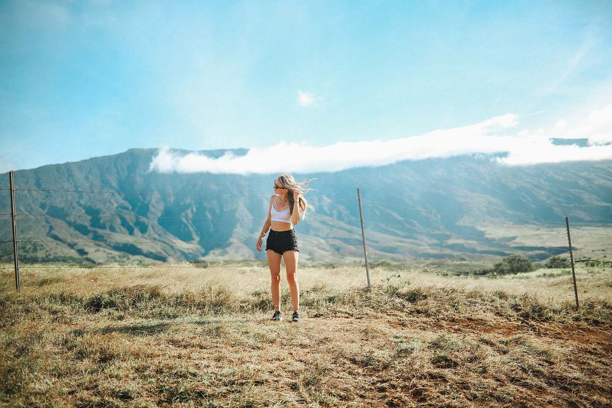 haleakala crater woman standing on grass field near posts woman